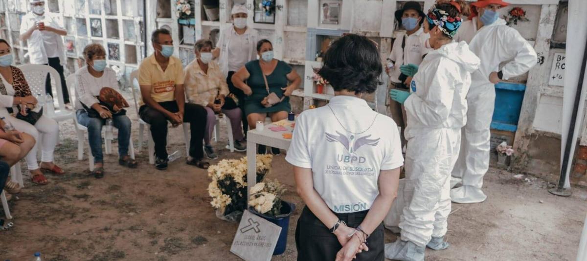 Familiares de v??ctimas de desaparici??n forzada y funcionarios de la Unidad de B??squeda de Personas dadas por Desaparecidas, durante una entrega digna de cuerpos en un cementerio.