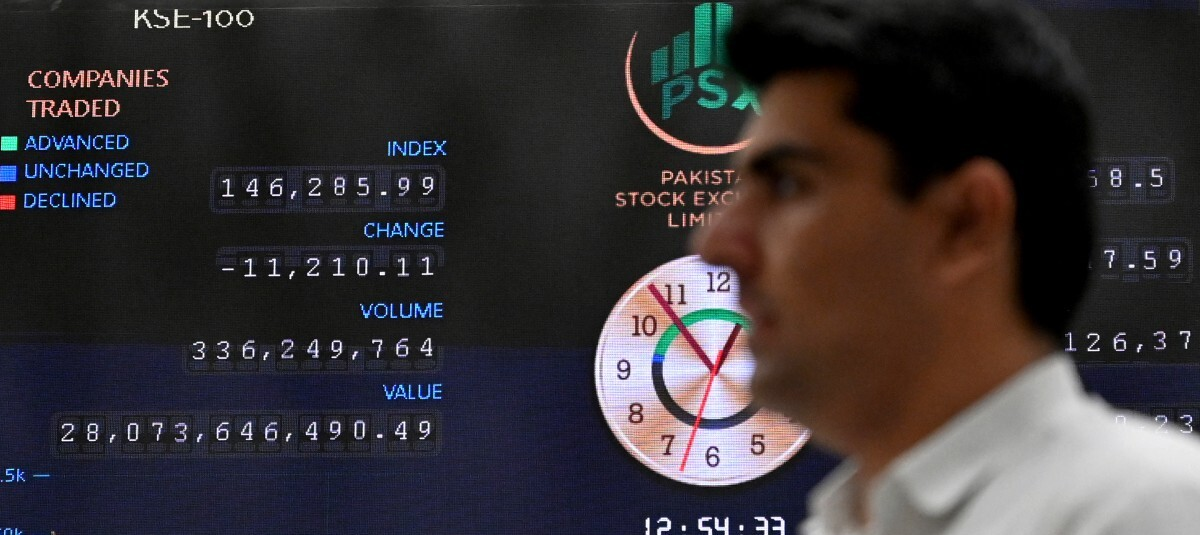 Un corredor de bolsa monitorea los precios de las acciones en un tablero digital en la Bolsa de Valores de Pakistán.