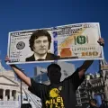 Un partidario del presidente electo de Argentina, Javier Milei, muestra un cartel con un billete de cien dólares.