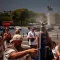 Personas se refrescan en una fuente de nebulización en la plaza del Trocadero durante una ola de calor en París, Francia