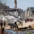Displaced Palestinians walk past tents and destroyed buildings as they return to their homes in the in al-Zahra area, north of the Nuseirat refugee camp in the central Gaza Strip, on October 14, 2025, a day after a ceasefire came into effect. The US president hailed a "tremendous day for the Middle East" as he and regional leaders signed a declaration on October 13, 2025 meant to cement a ceasefire in Gaza, hours after Israel and Hamas exchanged hostages and prisoners. (Photo by Eyad BABA / AFP)