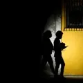 Una mujer alumbra con una linterna mientras camina con un hombre por una calle durante un apagón en La Habana, Cuba, el 16 de marzo de 2026