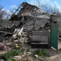 Policía ruso inspecciona una casa destruida en Yasynuvata, región de Donetsk, controlada por Rusia.