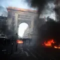Firefighters extinguish a car on fire near the Porte Saint-Denis during a demonstration to protest against the 