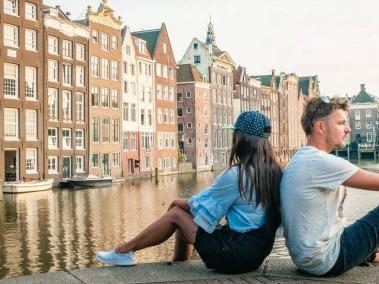BBC Mundo: Dos personas dándose la espalda sentados en un canal de Ámsterdam.