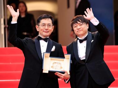El vicepresidente de eventos y exposiciones del Studio Ghibli, Kenichi Yoda, saluda junto al director japonés y director de desarrollo creativo del parque Ghibli, Goro Miyazaki, durante la ceremonia de entrega de la Palma dor honorífica en la 77 edición del Festival de Cine de Cannes, en Cannes, sur de Francia, el 20 de mayo de 2024. (Foto de Valery HACHE / AFP)