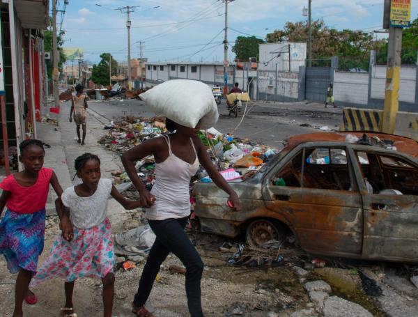 Gente huyendo de sus hogares tras un ataque de bandas criminales en Haití.
