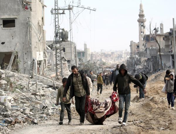 Palestinos transportan un cadáver recuperado de entre los escombros tras su regreso a Nuseirat, en el centro de la Franja de Gaza.