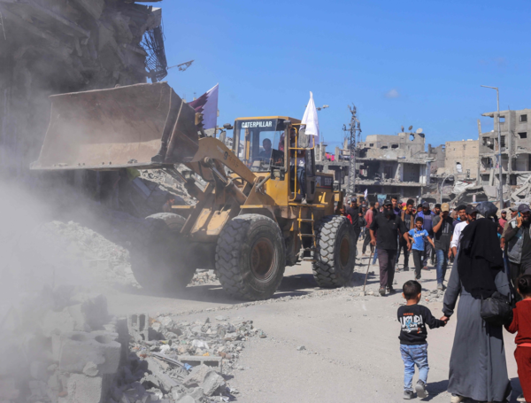 Palestinos se reúnen mientras el personal de la municipalidad de Gaza se prepara para desplegar excavadoras.