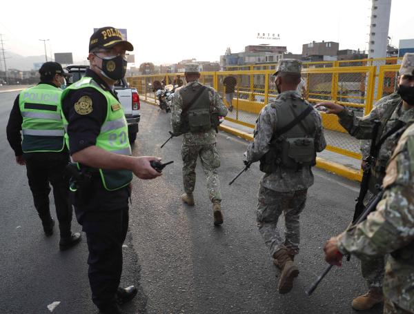 Militares y policías controlan un paradero de transporte público hoy martes en las calles de Lima.
