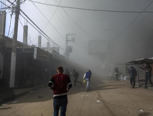 Palestinos observan el humo que se eleva durante un ataque aéreo israelí contra la mezquita Al Farouq en el campo de refugiados de Al Nuseirat, en el centro de la Franja de Gaza, el 23 de noviembre.