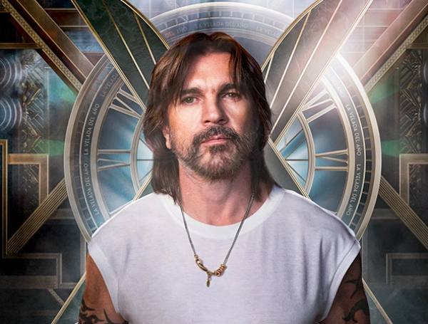 Juanes posando con el logo de La Velada del Año 6 de fondo