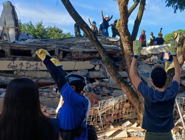 Rescatistas y ciudadanos forma una cadena de esperanza. El edificio Torres del Limonar en escombros.