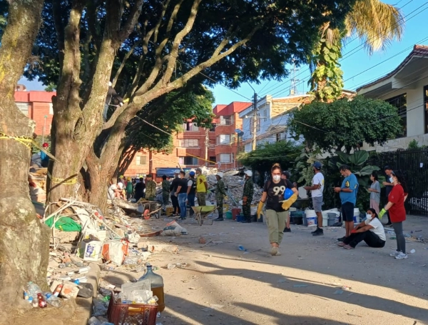 Rescatistas y ciudadanos forma una cadena de esperanza. El edificio Torres del Limonar en escombros.