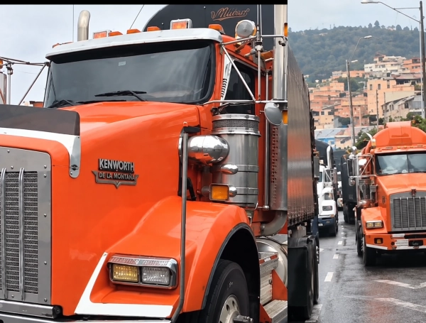 Convoy de camiones naranjas bajo la lluvia
