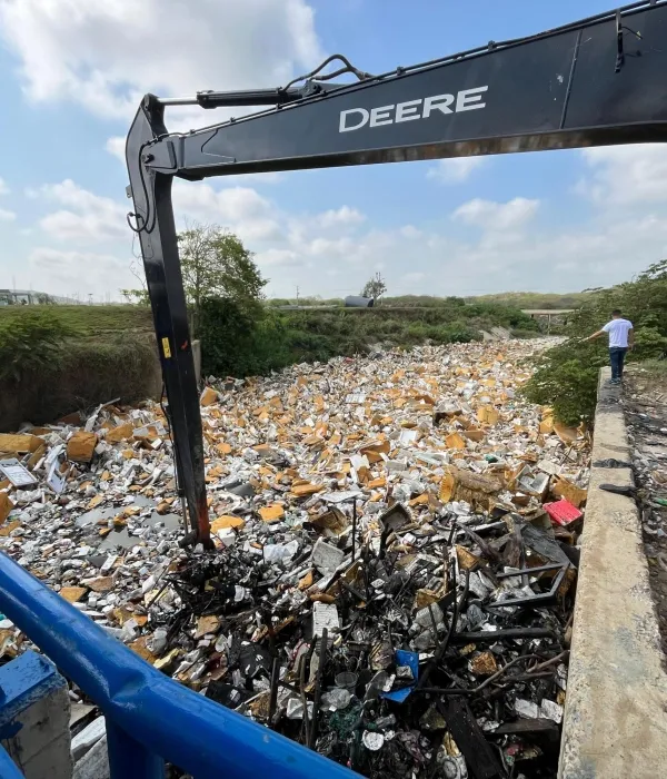Aspecto de las retroexcavadora sacando la basura de la trampa del arroyo León.