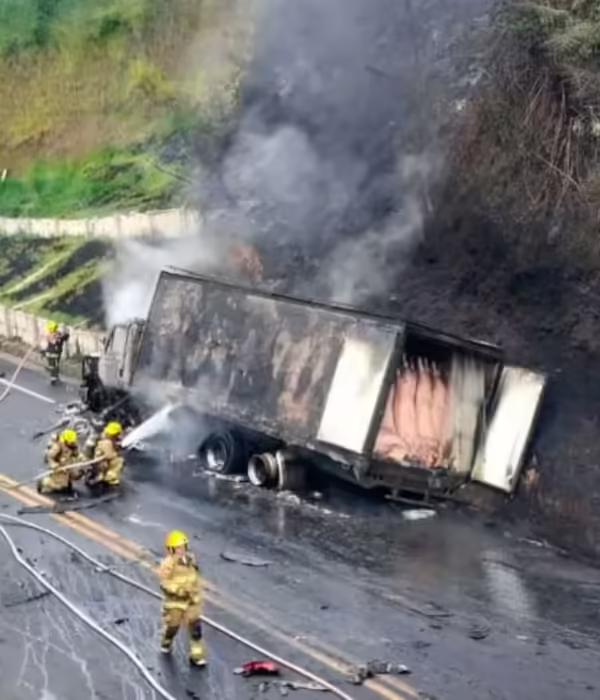 Los bomberos atacando el fuego que se produjo en el camión de transporte.