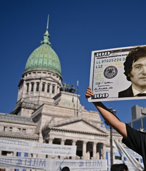 Un partidario del presidente electo de Argentina, Javier Milei, muestra un cartel con un billete de cien dólares.