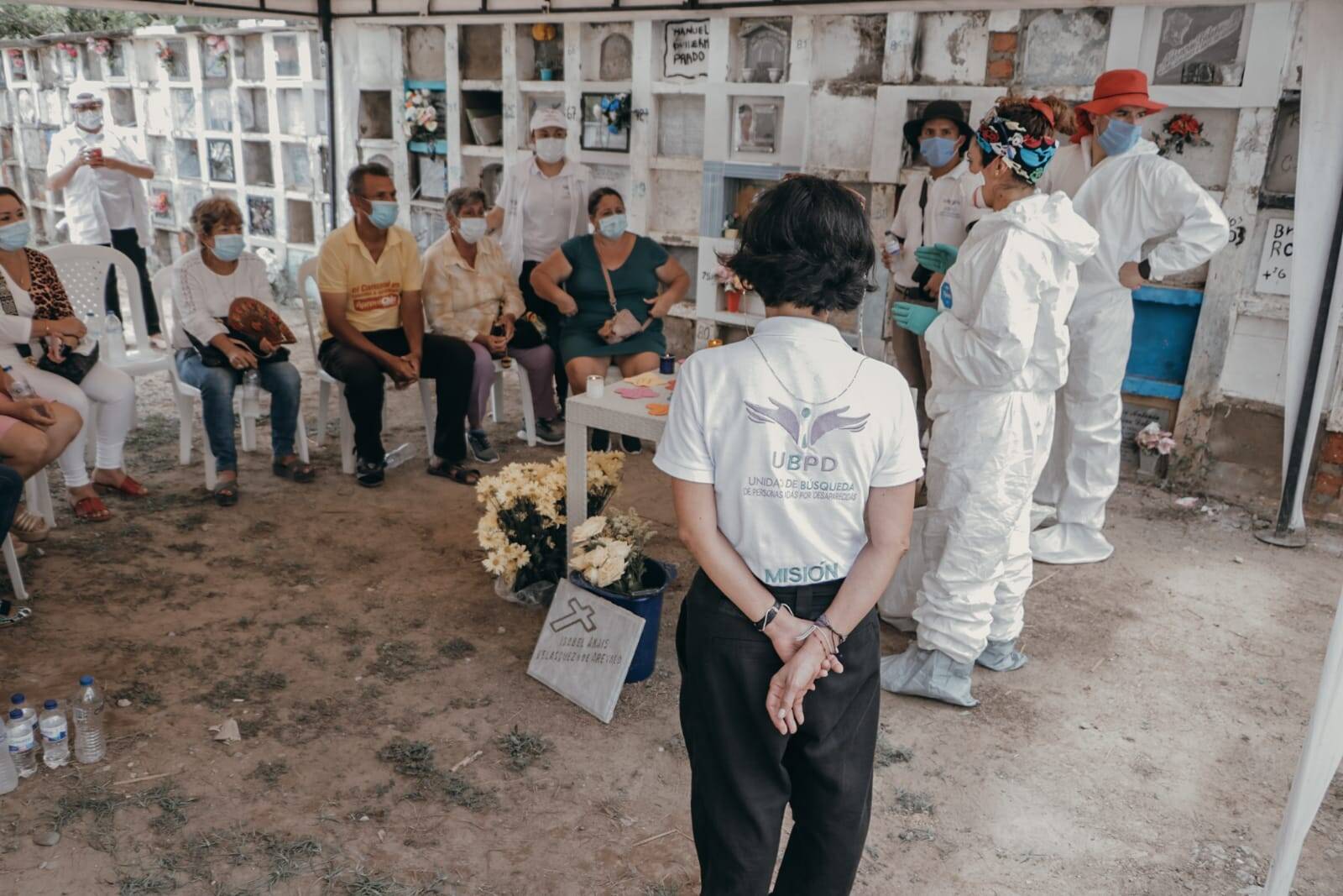 Familiares de víctimas de desaparición forzada y funcionarios de la Unidad de Búsqueda de Personas dadas por Desaparecidas, durante una entrega digna de cuerpos en un cementerio.