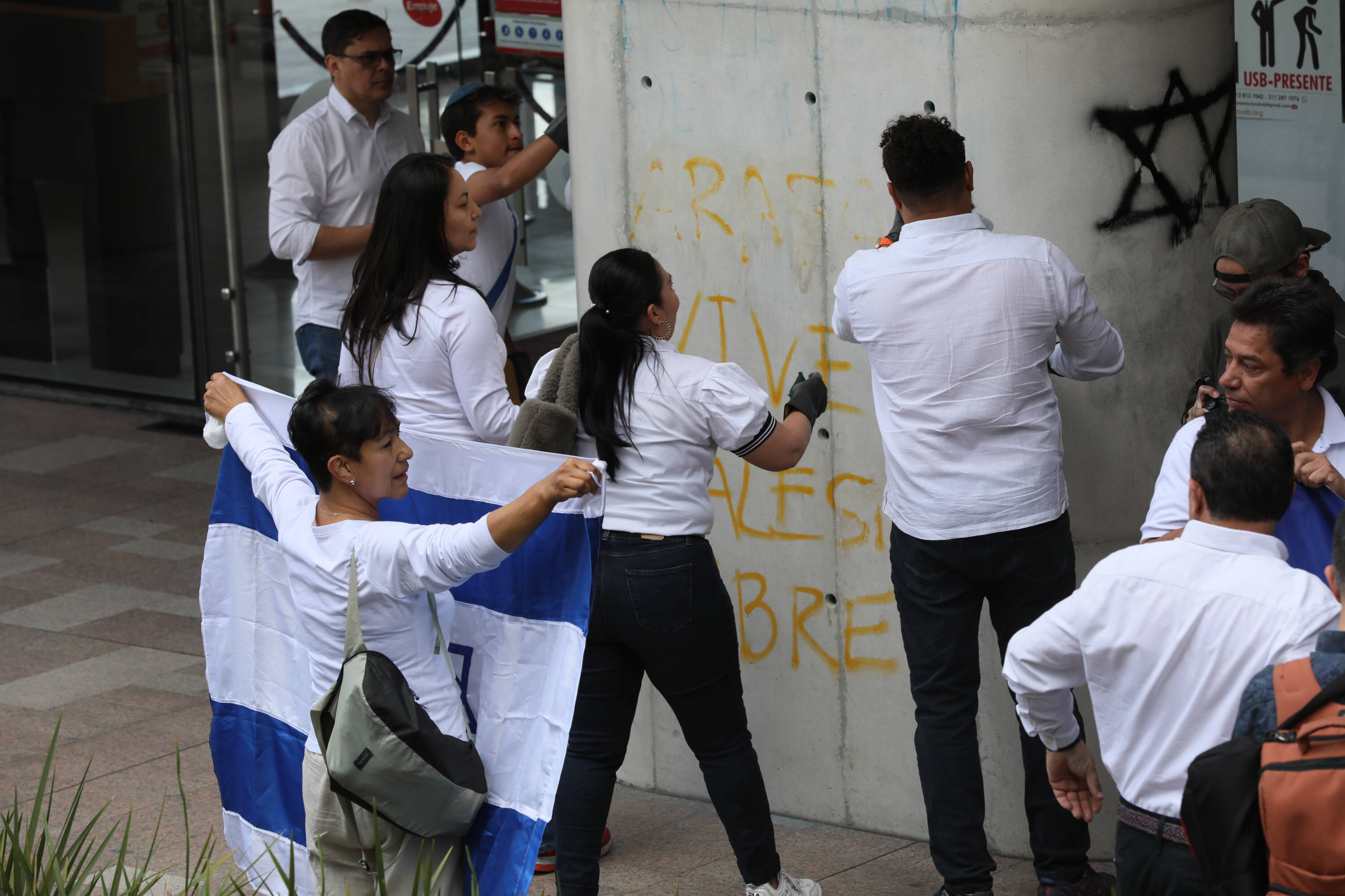 Grupo de ciudadanos se acerca a la embajada de Israel en Bogotá, para mostrar su apoyo ante los hechos terroristas en Israel. Limpieza de grafitis