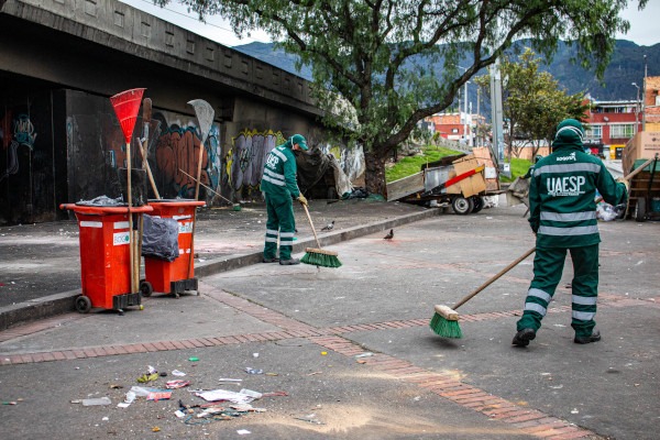 Trabajadores de la UAESP barriendo y recogiendo residuos.