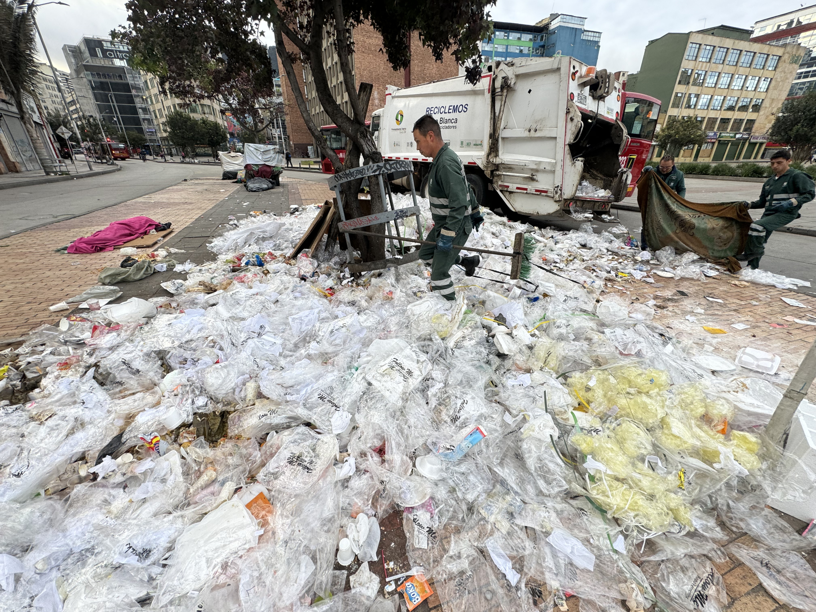 Funcionarios de la UAESP recogen los desechos que quedaron este 27 de mayo de 2024 frente a la estación de Transmilenio de la avenida Jiménez en el centro de la ciudad. FOTO MAURICIO MORENO CEET EL TIEMPO @mauriciomorenofoto