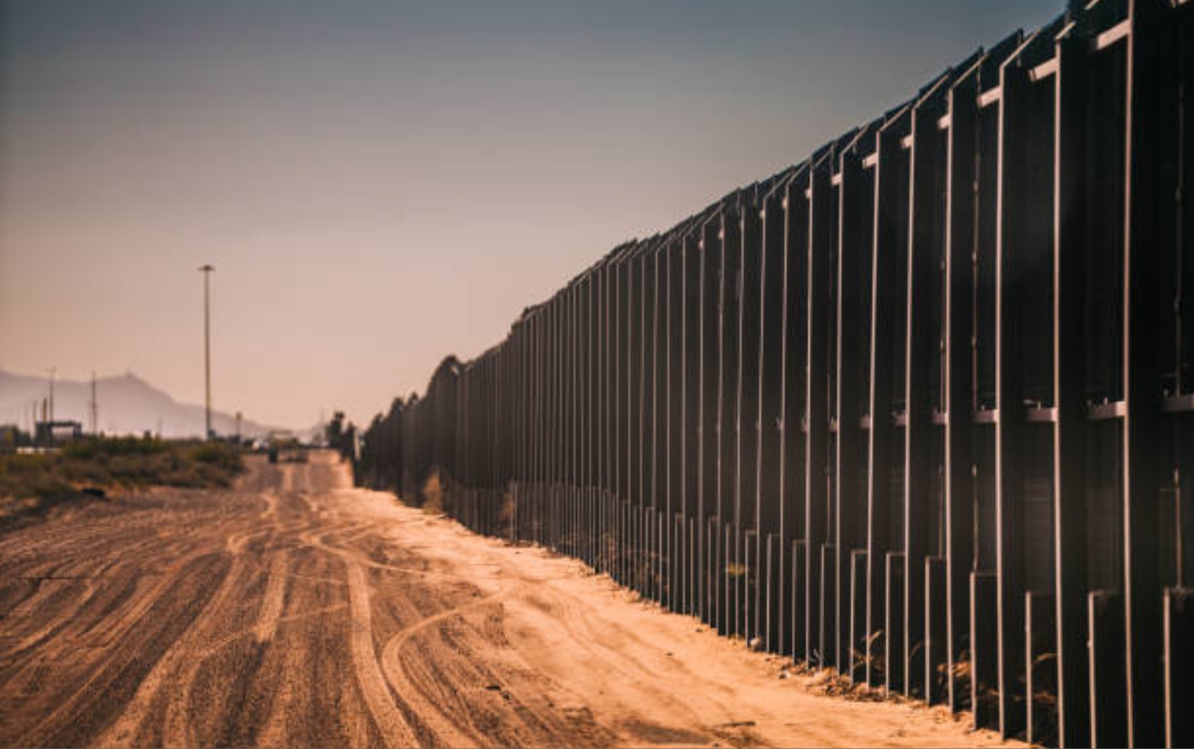 Carretera de servicio de la Patrulla Fronteriza de EE. UU. en el desierto a lo largo del muro fronterizo sur