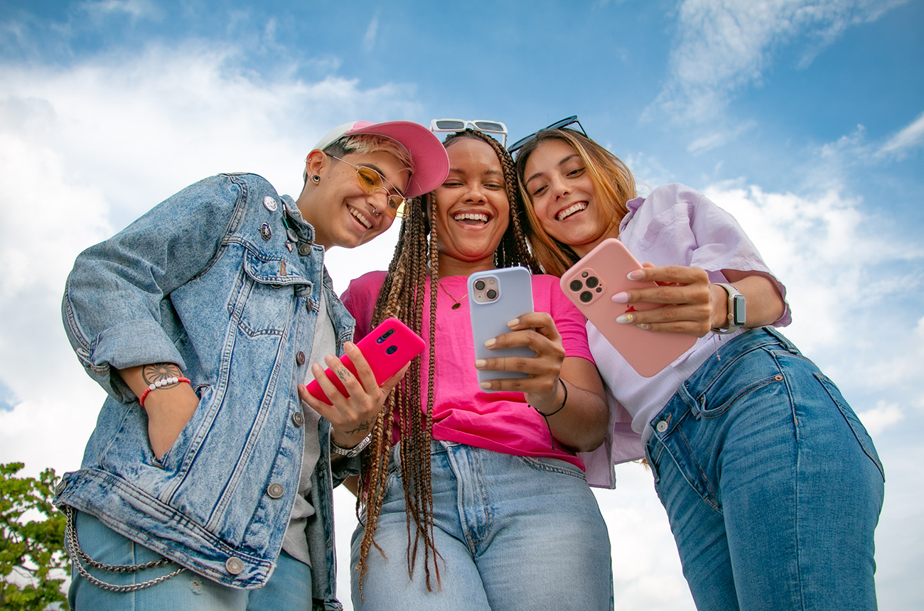 Amigas viendo su Nequi al aire libre