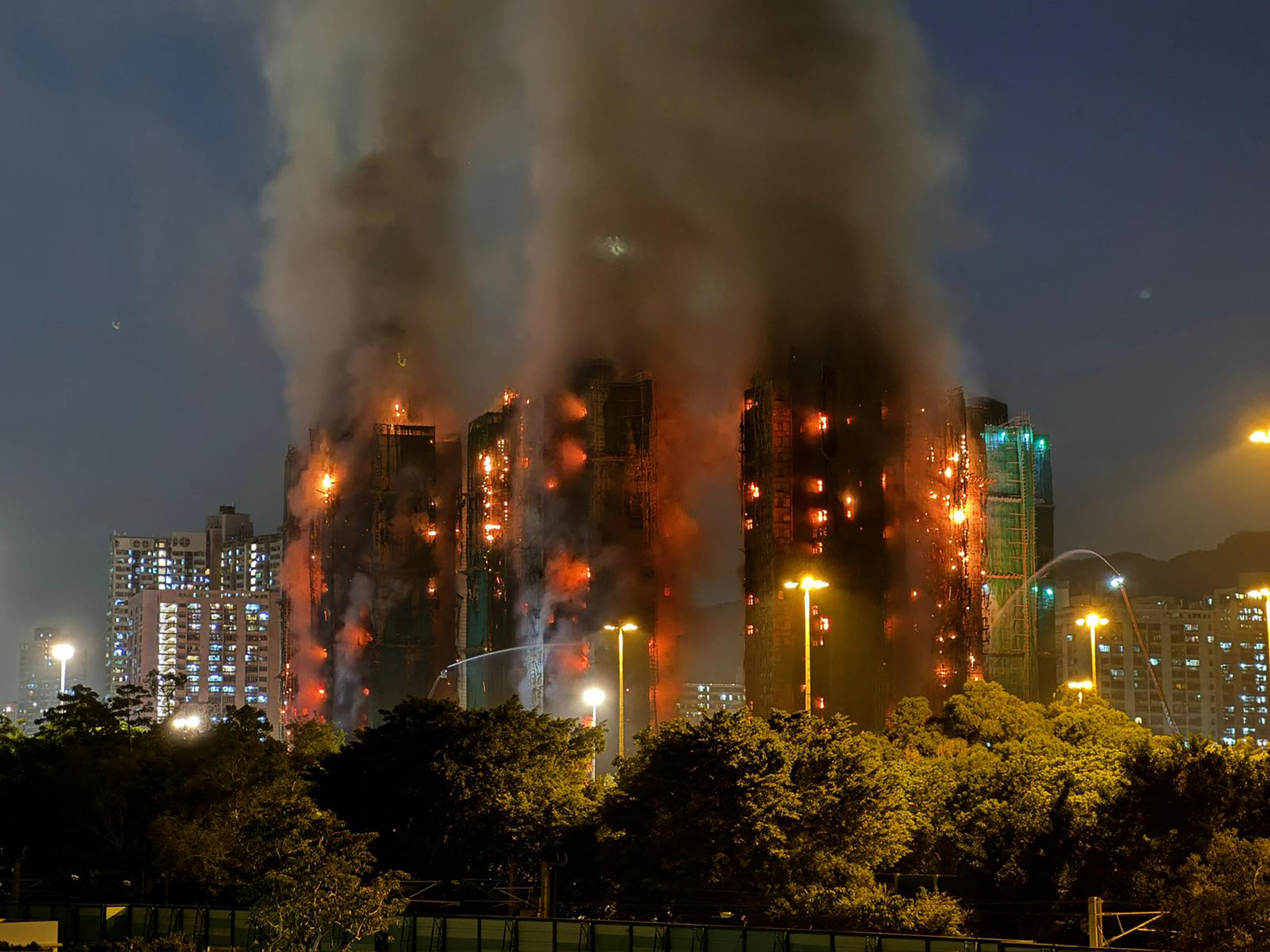 Una densa humareda y llamas se elevan mientras un gran incendio envuelve varios bloques de apartamentos en la urbanización Wang Fuk Court.