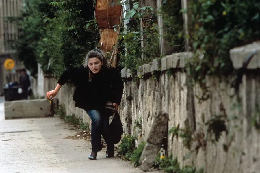 Una mujer corre a refugiarse del intenso fuego en Sarajevo.