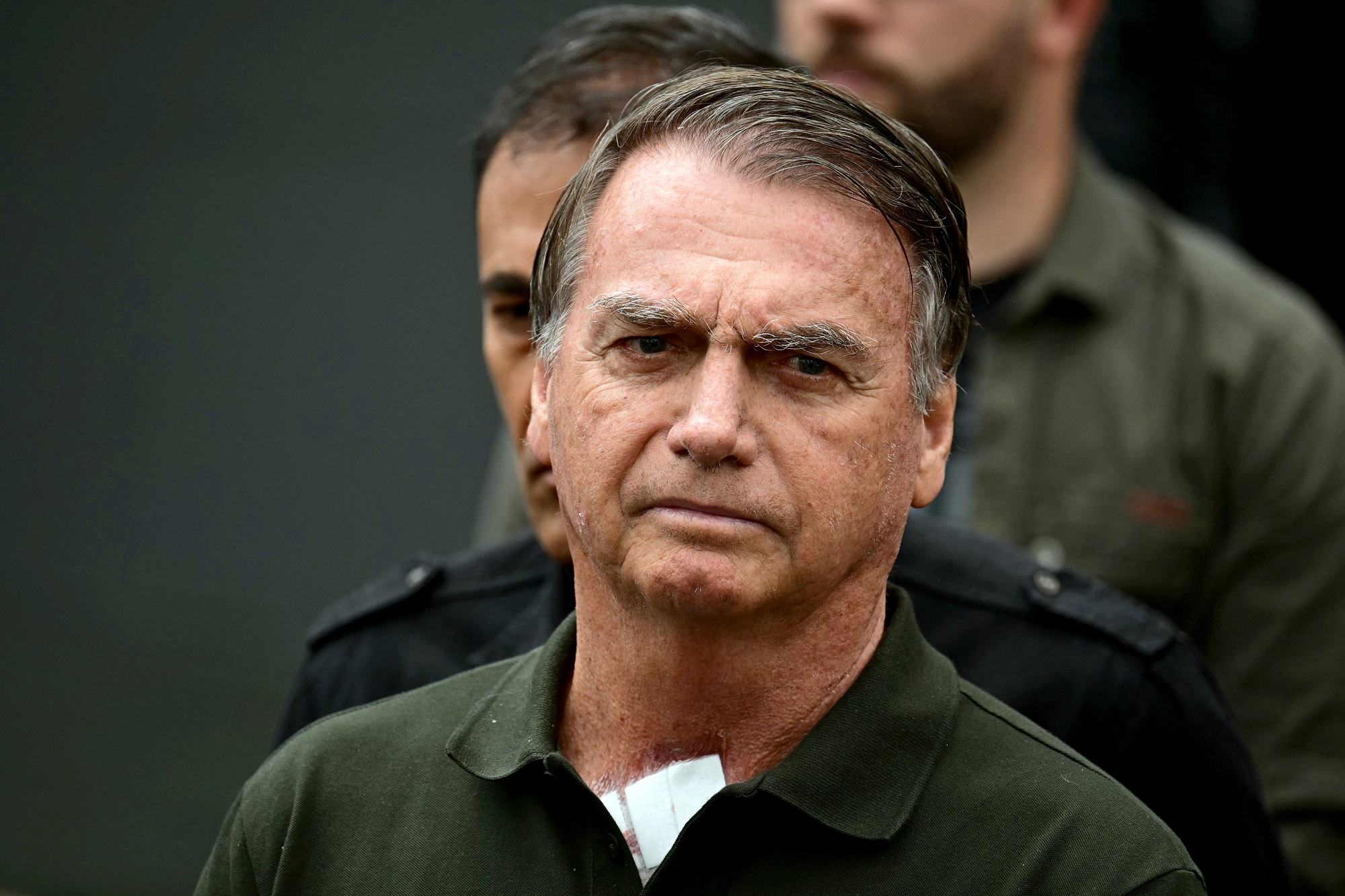 Un simpatizante del expresidente brasileño (2029-2023) Jair Bolsonaro, envuelto en una bandera israelí, reza junto a una bandera brasileña frente al Hospital DF Star