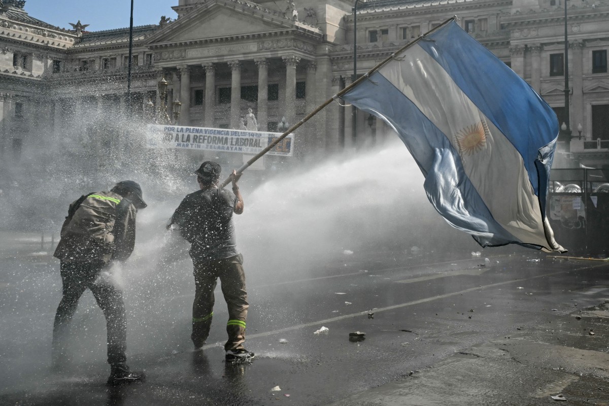 Manifestante ondea una bandera de Argentina frente al Congreso