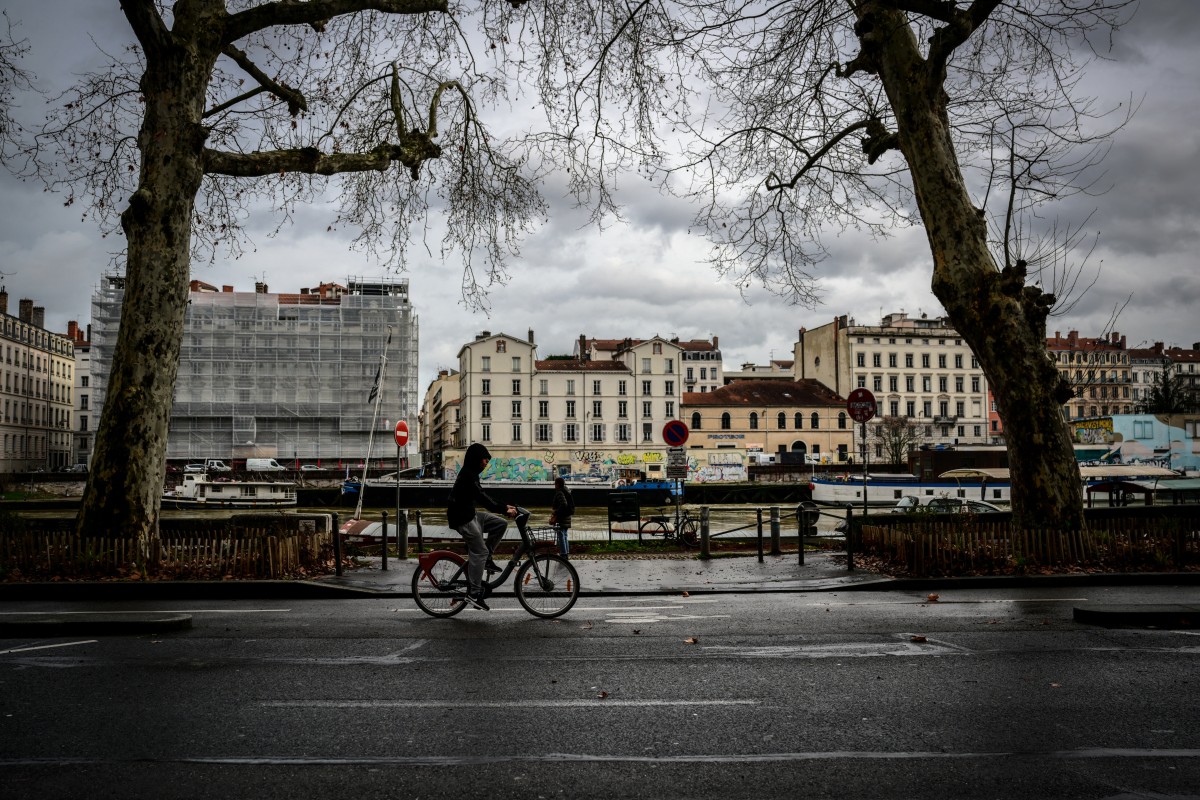 Un hombre pasea en bicicleta por el Quai Fulchiron, cerca del lugar de la pelea que causó la muerte de Quentin Deranque, Lyon, Francia