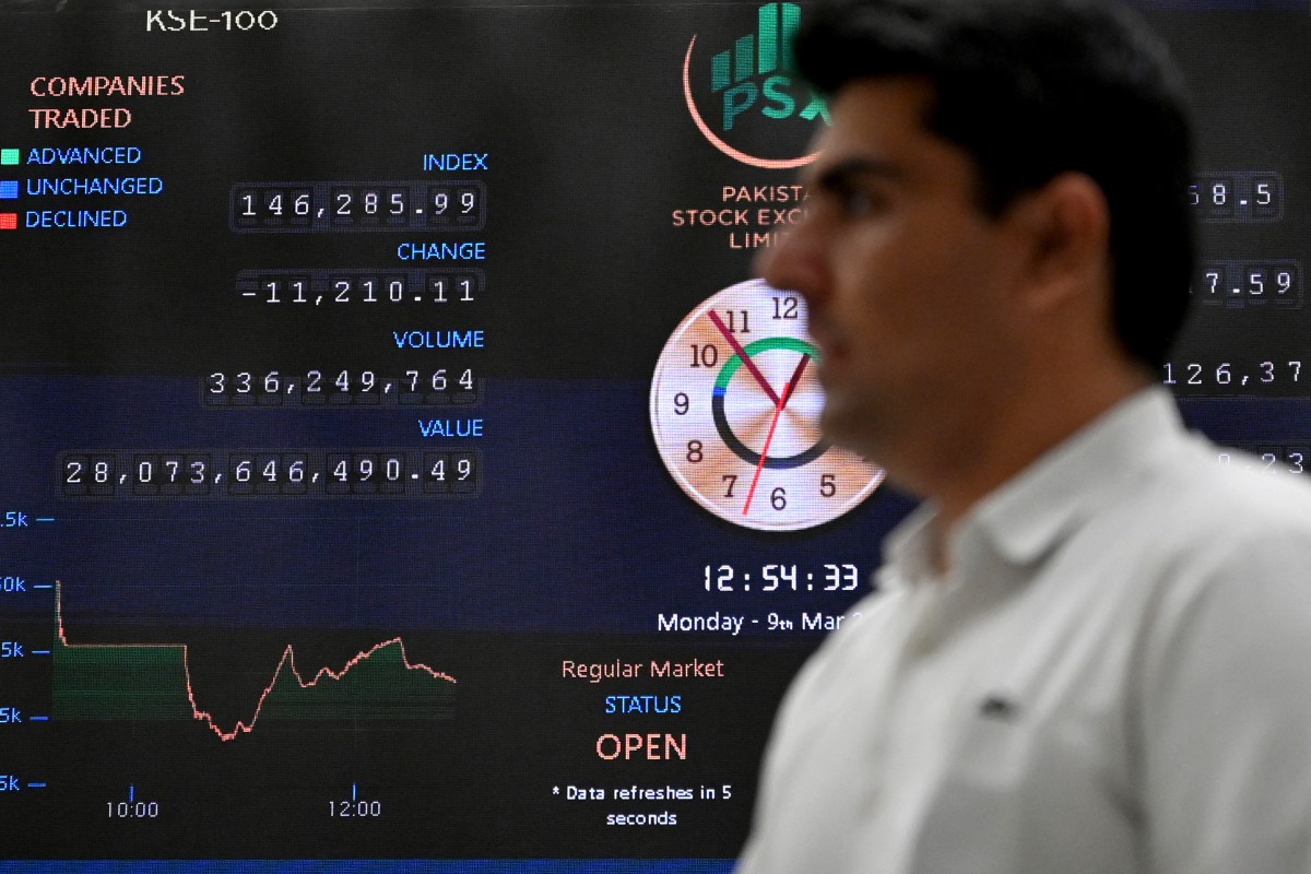 Un corredor de bolsa monitorea los precios de las acciones en un tablero digital en la Bolsa de Valores de Pakistán.