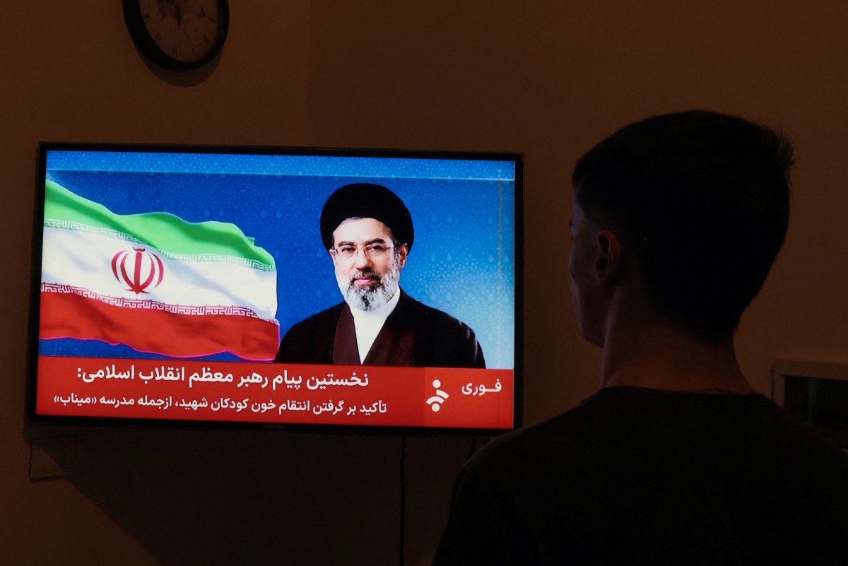 Un hombre observa la declaración televisada del nuevo líder supremo de Irán, Mojtaba Jamenei.