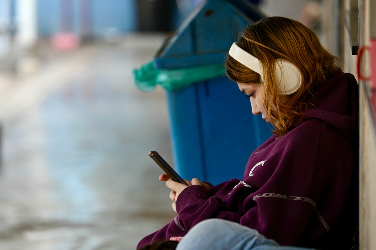 Una joven estudiante usa su celular