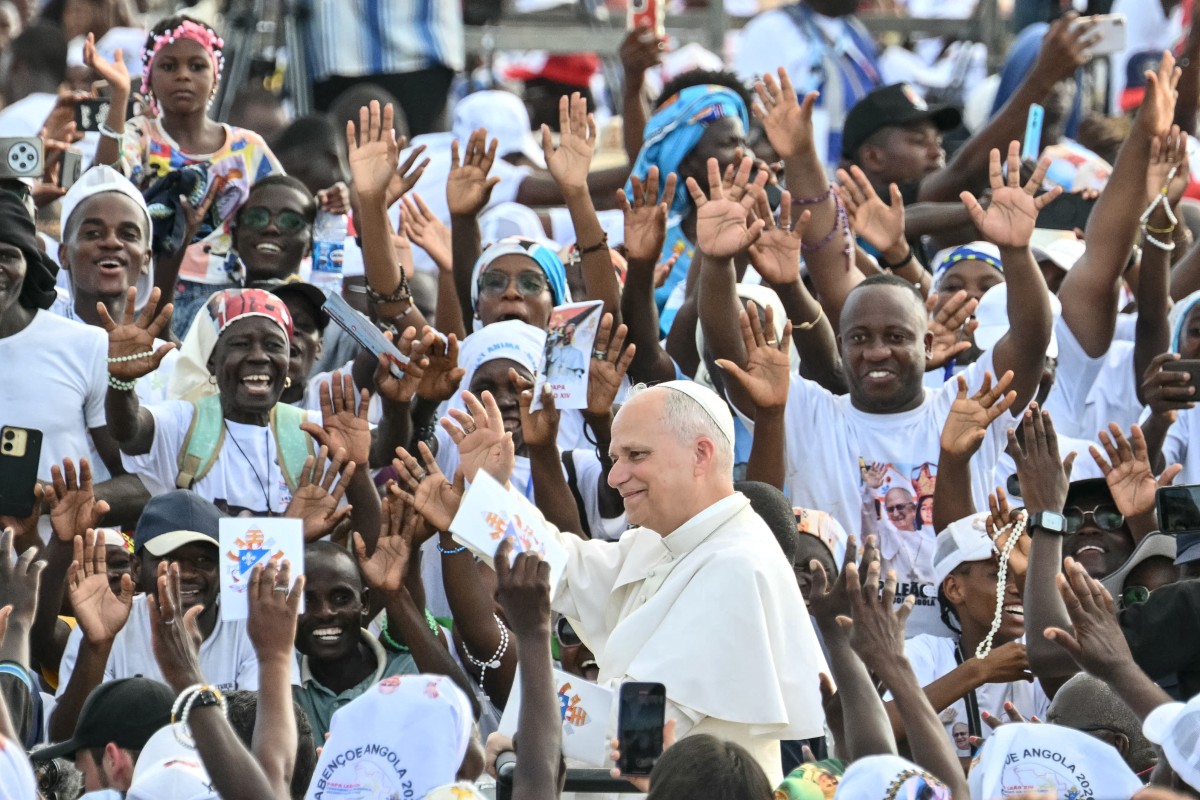 El papa León XIV (C) saluda a la multitud en Angola