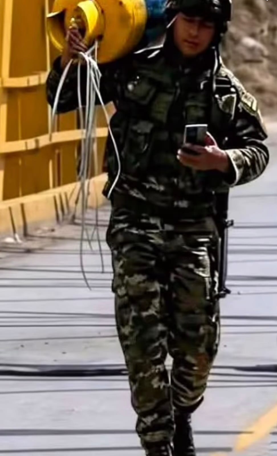 El soldado valiente con el cilindro bomba al hombro.