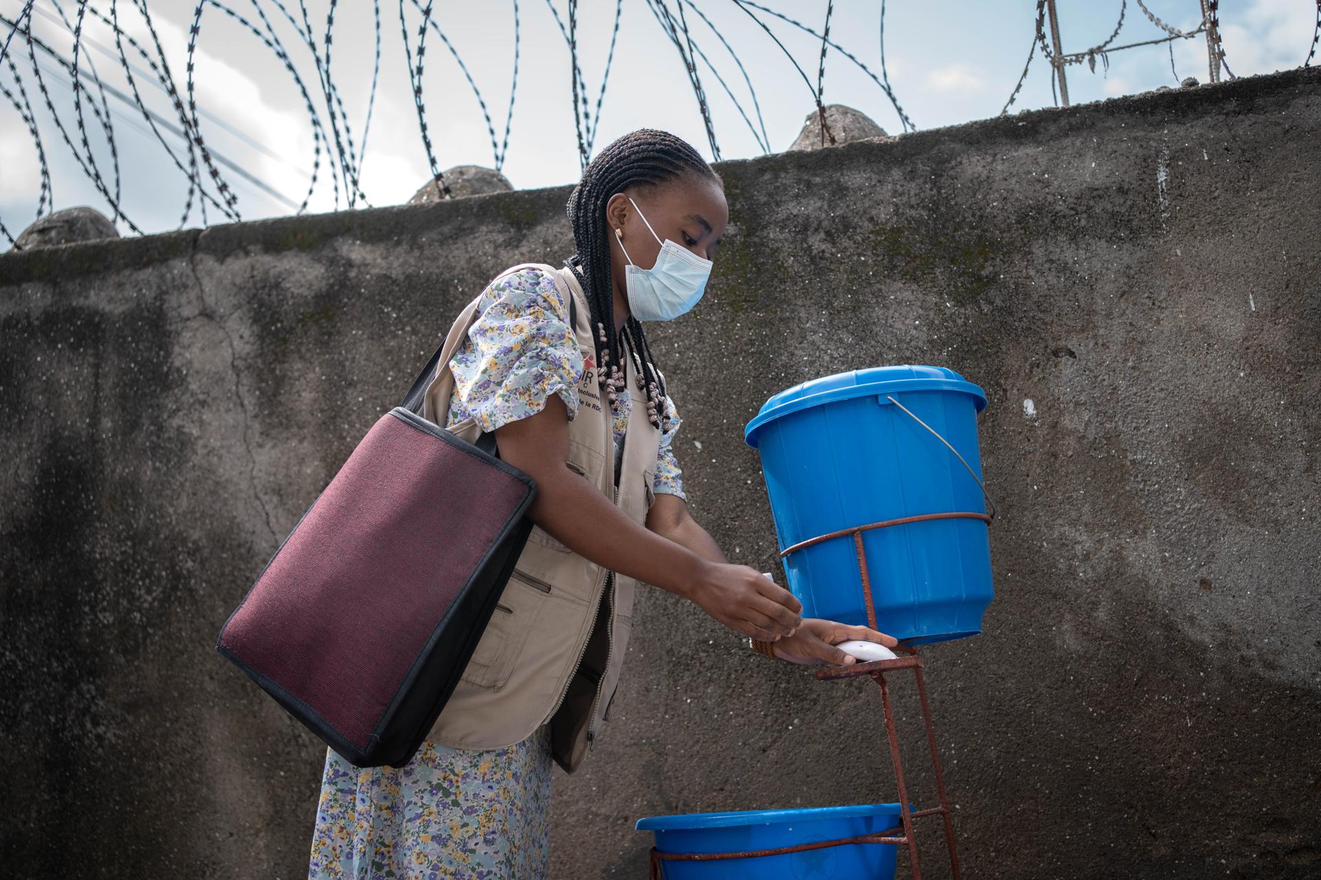 Mujer lleva mascarilla y se lava las manos como medida preventiva contra el ébola, en Goma, República Democrática del Congo