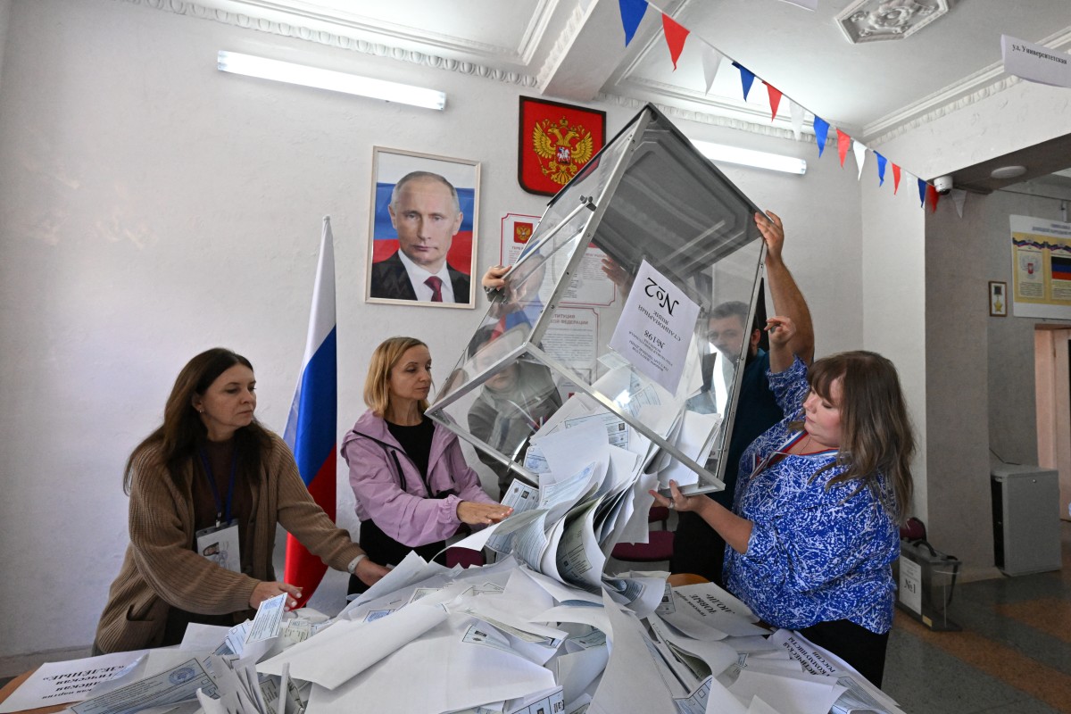 Miembros de una comisión electoral local vacían una urna para contar los votos en las elecciones parlamentarias rusas celebradas en Donetsk, Ucrania bajo control ruso.